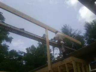 Carpenter setting a ridge beam over a new addition frame — Ice Dam Removal by Roofing Brothers in Deersville