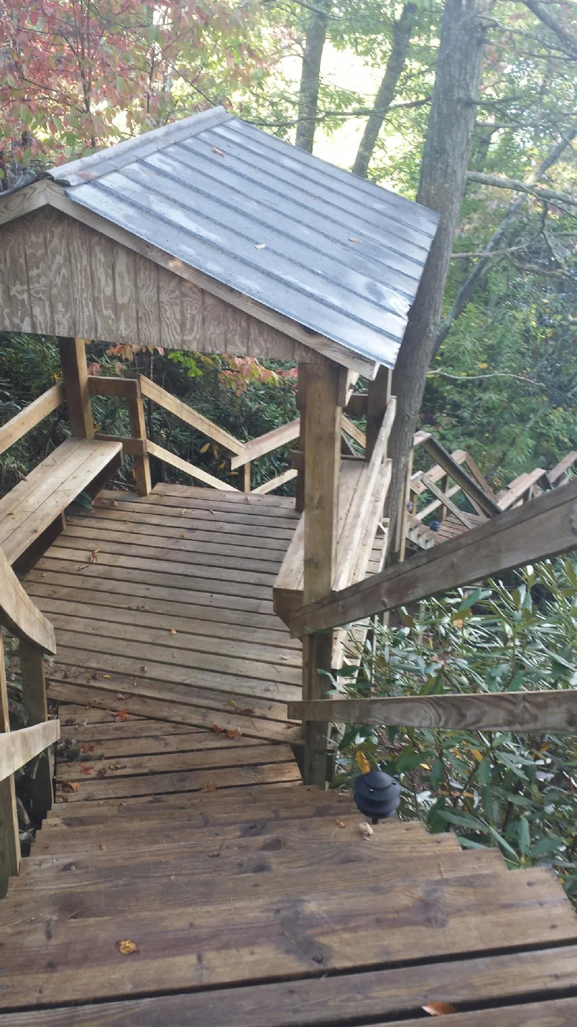 Metal roofed shelter over wooden steps on a wooded walkway — Skylight Repair & Installation work by our crew in Deersville