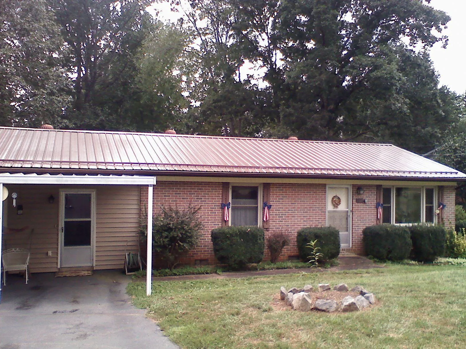 Bronze metal roof and carport on a brick ranch home — Roof Repair work by our crew in Deersville